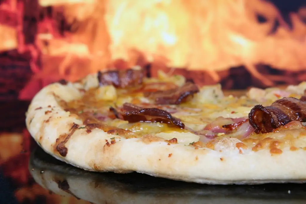 Une pizza qui cuit contre la braise du four