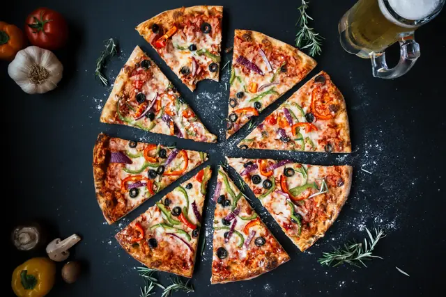 Une pizza en huit parts, le romarin autour — Agrandir