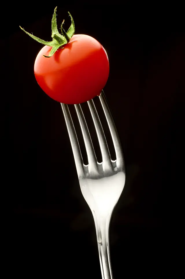 Une tomate rouge piquée sur une fourchette